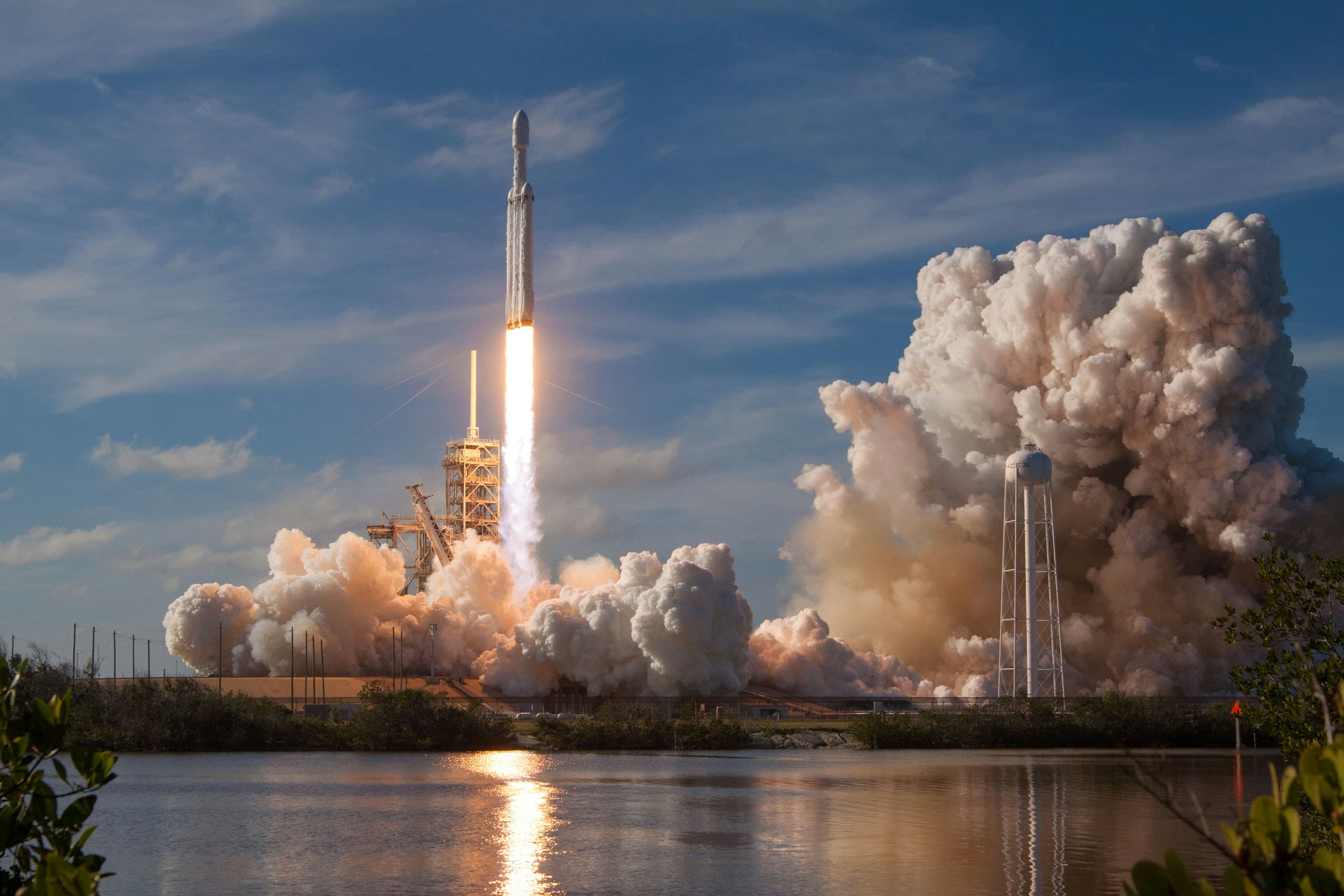A rocket launching with flames and lots of smoke and water vapor