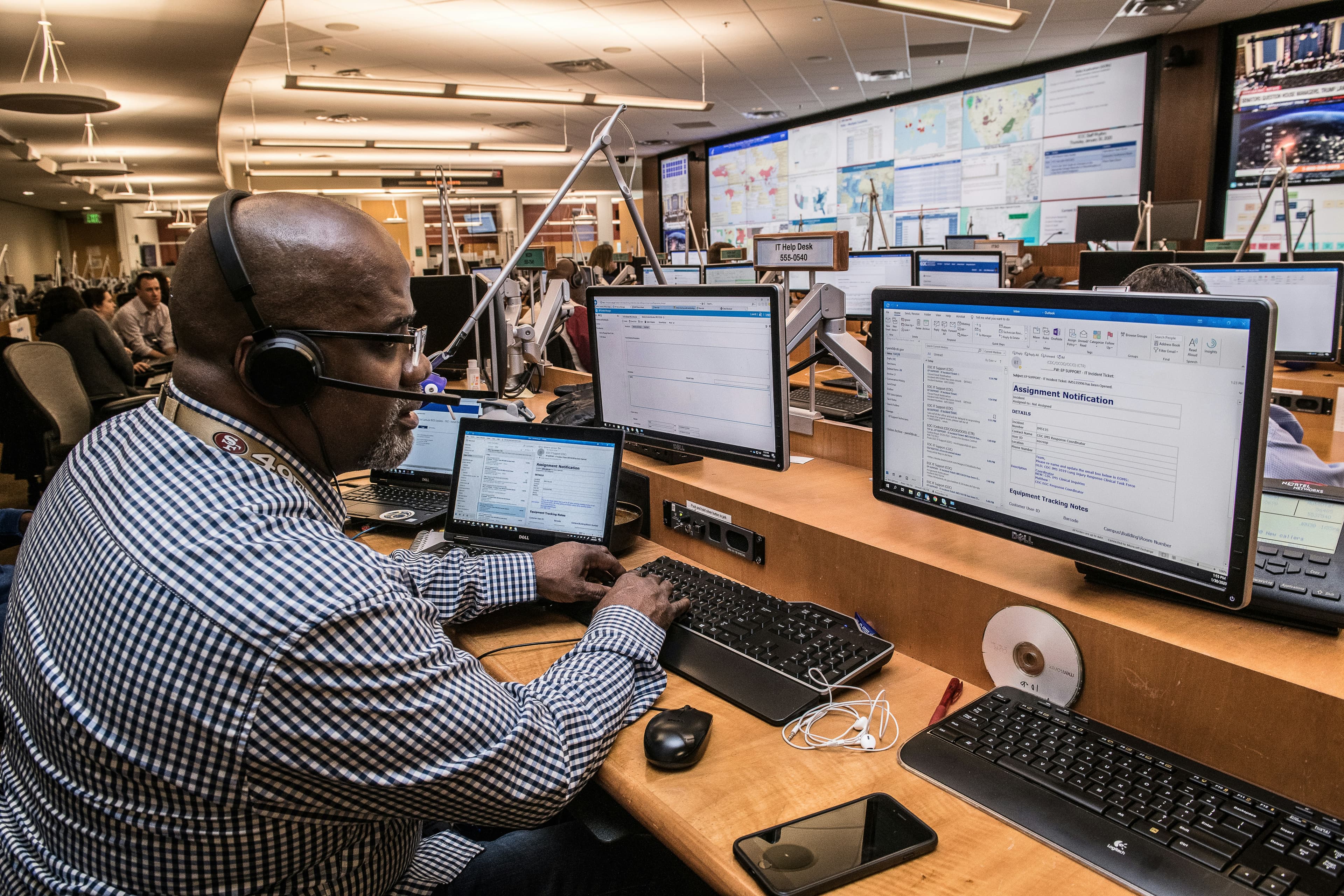 A man at a computer an an emergency dispatch call centre