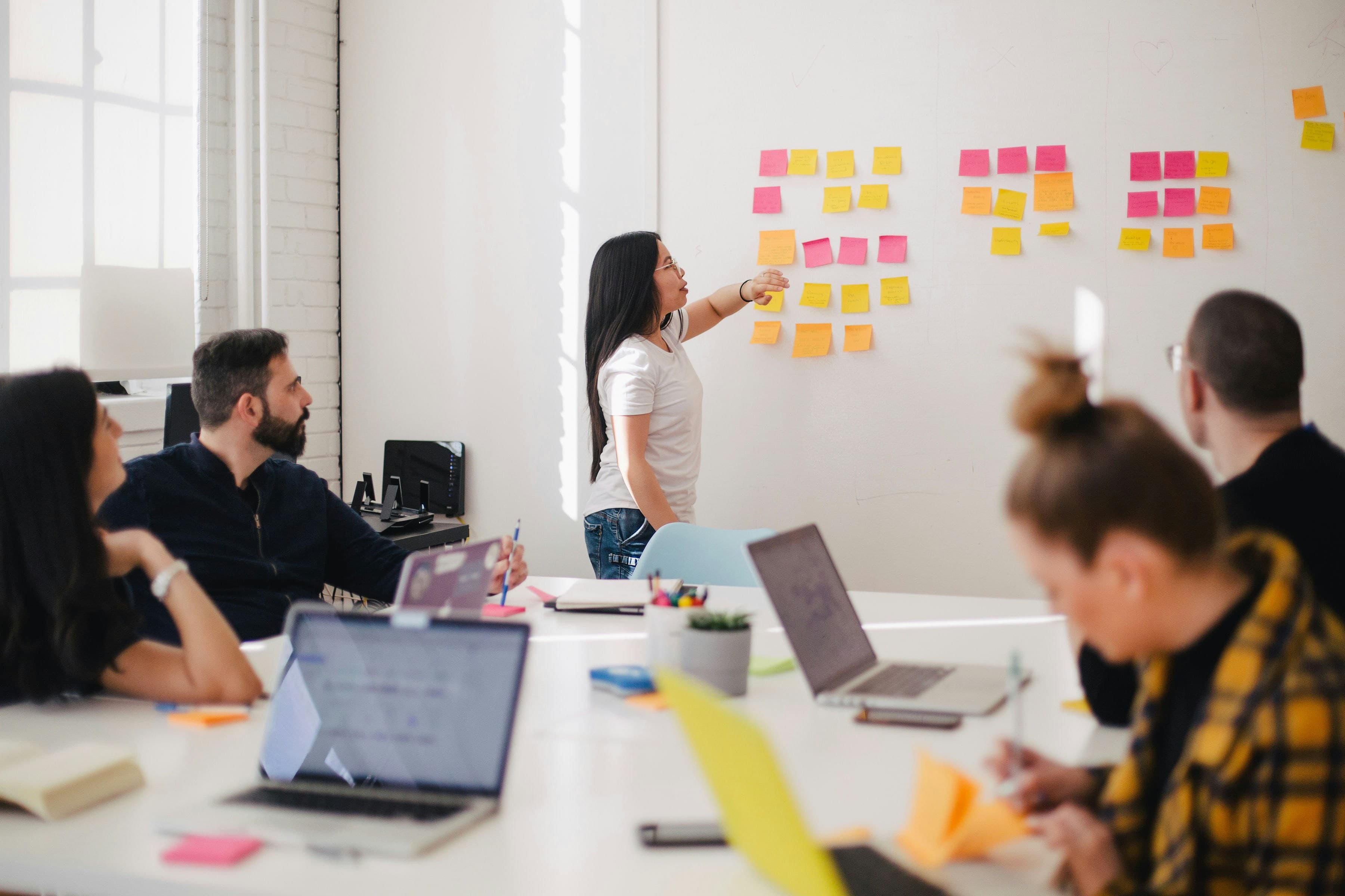 A group of people in a meeting room collaborating with sticky notes